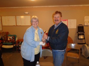 DG Lion Katherine Tweed (left) passes the gavel to incoming DGE Dwaine Heinrich.