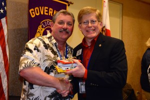 ID Robert receives prize from convention chair PDG Dan Mayer.